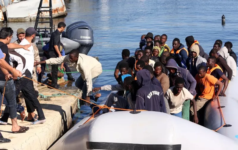 The Libyan coastguard pull a boat carrying illegal African migrants, rescued as they were trying to reach Europe, at a naval base near the capital Tripoli on September 29, 2015. The Libyan coastguard said it rescued 346 African migrants, almost 100 of them women and children, crammed onto rubber boats and stranded off the country's coast. AFP PHOTO/MAHMUD TURKIA