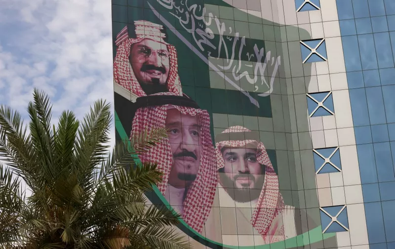 This picture shows a poster depicting King Abdulaziz bin Saud (L), the founder of the modern Kingdom of Saudi Arabia, King Salman bin Abdulaziz (C), and Crown Prince Mohammed in Riyadh on April 16, 2023. Saudi Arabia has put a second four-percent chunk of shares of the Aramco energy giant, worth tens of billions of dollars, under the control of the country's sovereign wealth fund, state media said. (Photo by Fayez Nureldine / AFP)