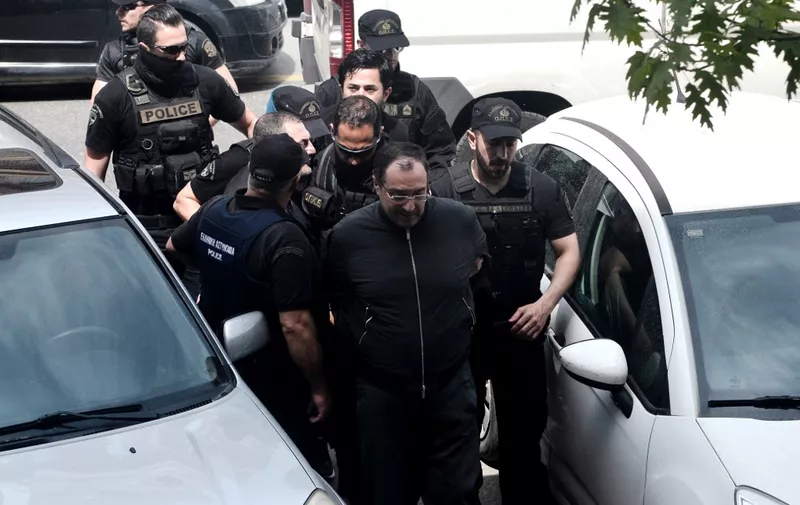 Lacha Chouchanachvili (C), a Georgian criminal wanted by France, is escorted by Greek police officers at courthouse in Thessaloniki after being arrested thanks to an International warrant issued against him, on April 18, 2018. Lacha Chouchanachvili, 57, was arrested following a police operation that began on the night of April 16, in Thessaloniki in which two other people, alleged accomplices, were arrested. (Photo by SAKIS MITROLIDIS / AFP)