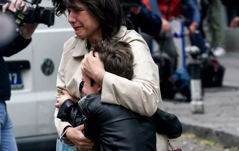 A parent escorts her child following a shooting at a school in the capital Belgrade on May 3, 2023. - Serbian police arrested a student following a shooting at an elementary school in the capital Belgrade on May 3, 2023, the interior ministry said. The shooting occurred at 8:40 am local time (06:40 GMT) at an elementary school in Belgrade's downtown Vracar district. (Photo by Oliver Bunic / AFP)