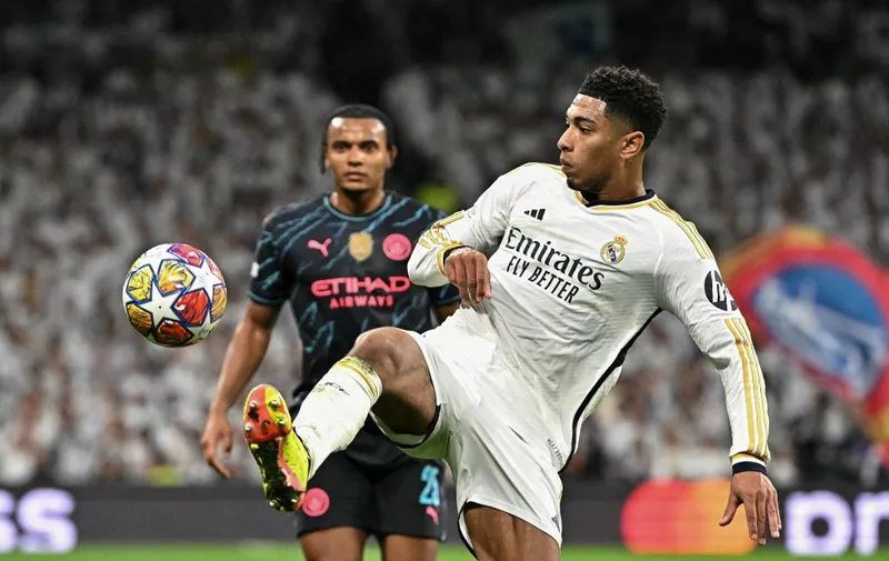Real Madrid's English midfielder #5 Jude Bellingham vies with Manchester City's Swiss defender #25 Manuel Akanji during the UEFA Champions League quarter final first leg football match between Real Madrid CF and Manchester City at the Santiago Bernabeu stadium in Madrid on April 9, 2024. (Photo by JAVIER SORIANO / AFP)