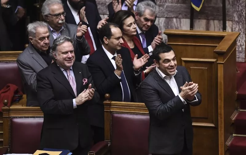 Greece's Prime Minister Alexis Tsipras (R) and Alternate Minister of Foreign Affairs Georgios Katrougalos (L) applaud and celebrate following a voting session on the Prespa Agreement, an agreement aimed at ending a 27-year bilateral row by changing the name of Macedonia to the Republic of North Macedonia, at the Greek Parliament, in Athens, on January 25, 2019. - Macedonian Prime Minister Zoran Zaev congratulated on January 25, 2019 his Greek counterpart for a "historic victory" after Greek lawmakers ratified a landmark name change deal with neighbouring Macedonia. (Photo by ANGELOS TZORTZINIS / AFP)