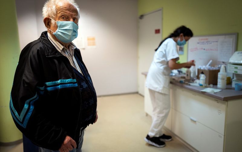 An employee of the Les Cazelles retirement home prepares to vaccinate Etienne Fabre, a 92-year-old resident, against the seasonnal flu in Bozouls, southern France, on October 14, 2020. - France's national seasonal flu vaccine campaign started on October 13, amid a surge of infections in the Covid-19 (novel coronavirus) outbreak. Health authorities aim at nearing 75 percent of flu vaccination coverage for people at risk, a much higher target the previous year's 47,8 percent. (Photo by Lionel BONAVENTURE / AFP)