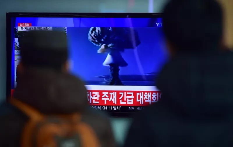 ADDITION-
People watch a news report on North Korea's first hydrogen bomb test at a railroad station in Seoul on January 6, 2016. South Korea "strongly" condemned North Korea's shock hydrogen bomb test and vowed to take "all necessary measures" to penalise its nuclear-armed neighbour.  The image shown on TV shows files images from other nuclear tests from other countries and the caption in red at the bottom of the screen reads "the Blue House will convene an emergency meeting of the NSC, the National Security Council."   AFP PHOTO / JUNG YEON-JE / AFP / JUNG YEON-JE