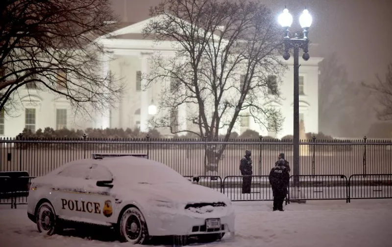 US Secret Service Agents stand guard outside the White House during a snowstorm in downtown Washington, DC on January 22, 2016.   A monster blizzard threatening the US East Coast slammed into Washington on January 22, blanketing the nation's capital in snow as officials urged millions in the storm's path to seek shelter, warning the worst was yet to come.      AFP PHOTO / Mladen ANTONOV / AFP / MLADEN ANTONOV
