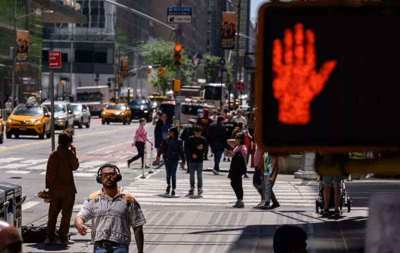 A street sign is displayed before pedestrians on a street in New York on May 26, 2023. (Photo by Ed JONES / AFP)