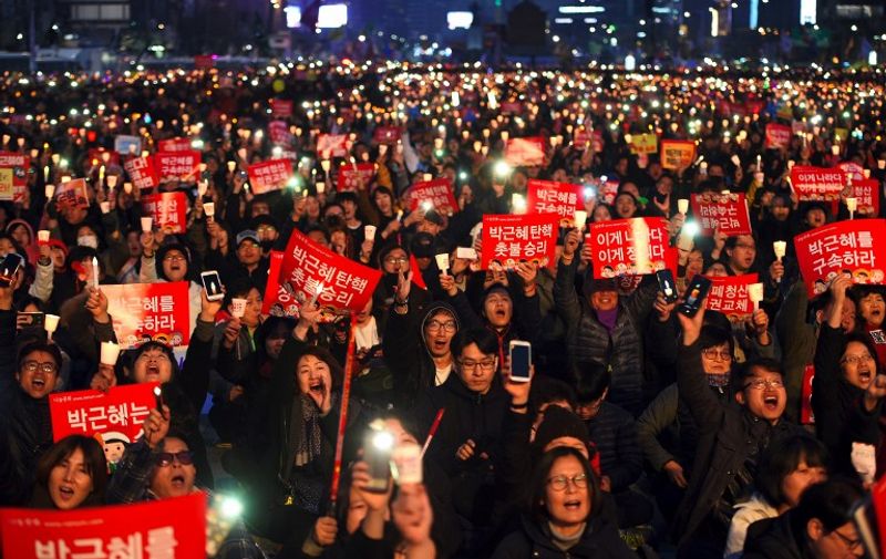 South Korean demonstrators hold up candles during a candlelit rally demanding arrest of Park Geun-Hye in Seoul on March 11, 2017.
South Korea's ousted leader Park Geun-Hye was holed up in the presidential Blue House Saturday as protesters took to Seoul's streets demanding her arrest, a day after a court upheld her impeachment. / AFP PHOTO / JUNG Yeon-Je