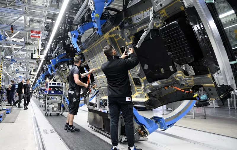 Employees of German car maker Mercedes-Benz work on the bottom side of an EQS passenger car at the 'Factory 56', a completely digitized assembly line, at the Mercedes-Benz manufacturing plant in Sindelfingen, southwestern Germany, on February 13, 2023. Mercedes-Benz will present their 2022 annual results on February 17, 2023. (Photo by THOMAS KIENZLE / AFP)
