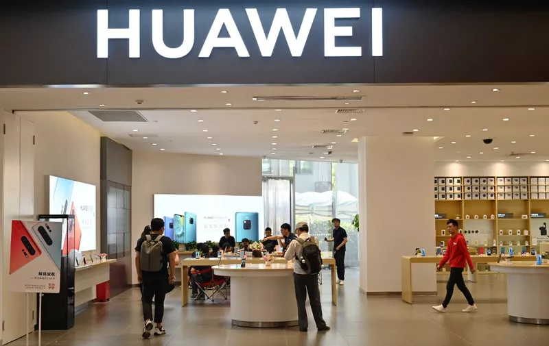 People browse for items in a Huawei store in a shopping mall in Shanghai on May 22, 2019. (Photo by Hector RETAMAL / AFP)
