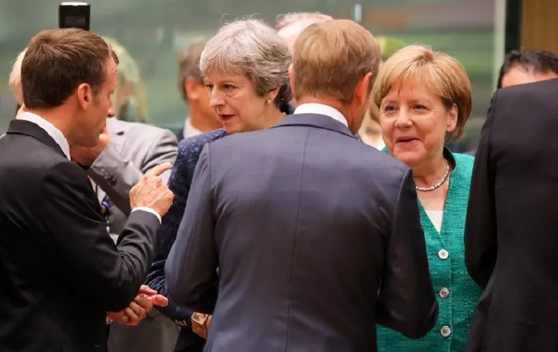 France's President Emmanuel Macron (L) speaks with Britain's Prime Minister Theresa May (2ndL) as European Council President Donald Tusk (2ndR) speaks with Germany's Chancellor Angela Merkel during an European Union leaders' summit focused on migration, Brexit and eurozone reforms on June 28, 2018 at the Europa building in Brussels.
The two-day meeting in Brussels is expected to be dominated by deep divisions over migration, with German Chancellor saying the issue could decide the fate of the bloc itself. / AFP PHOTO / Ludovic MARIN