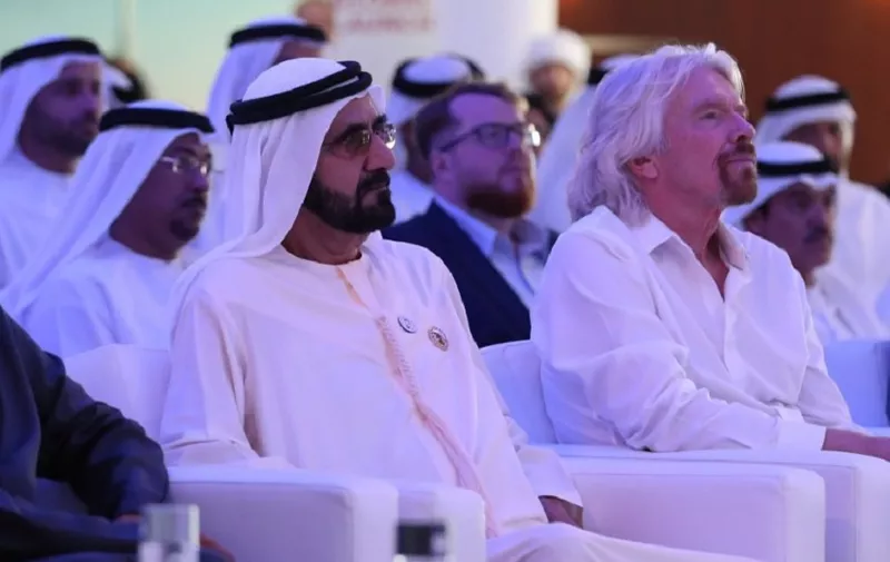 Sheikh Mohammed bin Rashid al-Maktoum (L), Vice-President and Prime Minister of the UAE and Ruler of Dubai, sits with Sir Richard Branson (R), CEO of the Virgin group, in Dubai on April 29, 2018, during the unveiling of the DP World CargoSpeed a partnership to build a hyperloop system for cargo in the UAE. (Photo by KARIM SAHIB / AFP)