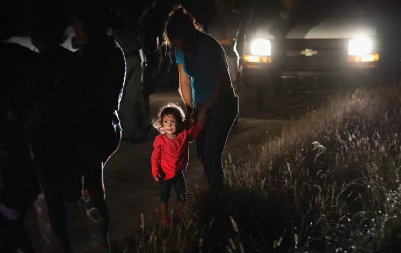 MCALLEN, TX - JUNE 12: A two-year-old Honduran stands with her mother after being detained by U.S. Border Patrol agents near the U.S.-Mexico border on June 12, 2018 in McAllen, Texas. The asylum seekers had rafted across the Rio Grande from Mexico and were detained before being sent to a Border Patrol processing center for possible separation. Customs and Border Protection (CBP) is executing the Trump administration's "zero tolerance" policy towards undocumented immigrants. U.S. Attorney General Jeff Sessions also said that domestic and gang violence in immigrants' country of origin would no longer qualify them for political asylum status.   John Moore/Getty Images/AFP