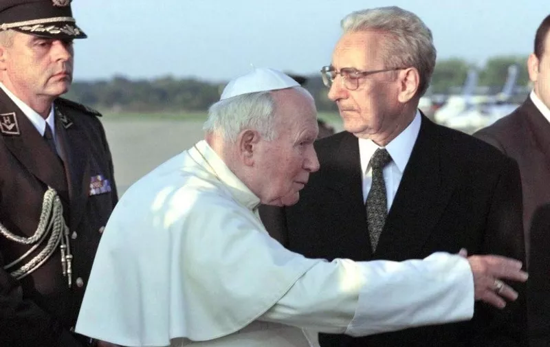 Pope John Paul II gestures after he was greeted  airport by Croatian President Franjo Tudjman (R) at Zagreb airport 02 October. Pope John Paul II arrived for a three day visit to Croatia where he will beatify Croatian Cardinal Alojzije Stepinac, who was accused by the Serbs of collaboration with Ante Pavelic's Ustasha regime, while the Croats regard him as a symbol of their struggle for independence. Official at (L) is unidentified.    (ELECTRONIC IMAGE) 
 / AFP PHOTO / GERARD JULIEN