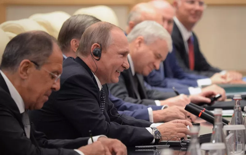 Russian President Vladimir Putin (2nd L) smiles as he meets with Chinese President Xi Jinping (not pictured) at the West Lake State Guest House in Hangzhou on September 4, 2016. - G20 leaders meet, charged with reviving the sluggish world economy, but a growing anti-globalisation mood and alarm over China's territorial ambitions loom over the summit in the scenic city of Hangzhou. (Photo by WANG ZHAO / POOL / AFP)