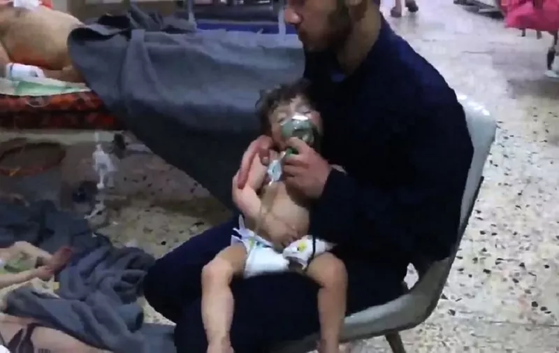 An image grab taken from a video released by the Syrian civil defence in Douma shows unidentified volunteers giving aid to children at a hospital following an alleged chemical attack on the rebel-held town on April 8, 2018.
A suspected chemical attack by Syria's regime sparked international outrage, after rescue workers reported dozens killed by poison gas on rebel-held parts of Eastern Ghouta near Damascus. President Bashar al-Assad's regime and its ally Russia denied the allegations of a chlorine gas attack on the town of Douma, calling them "fabrications". 
 / AFP PHOTO / AFP PHOTO AND SYRIA CIVIL DEFENCE / HO / === RESTRICTED TO EDITORIAL USE - MANDATORY CREDIT "AFP PHOTO / HO / SYRIA CIVIL DEFENCE" - NO MARKETING NO ADVERTISING CAMPAIGNS - DISTRIBUTED AS A SERVICE TO CLIENTS ===