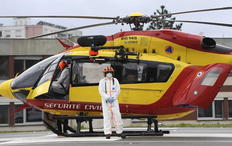 The helicopter pilot of the civil security (Securite Civile) poses with his protective suit after the transfer of a patient infected with the Covid-19 novel coronavirus from Lyon to Strasbourg University Hospital, eastern France, on November 12, 2020. (Photo by FREDERICK FLORIN / AFP)
