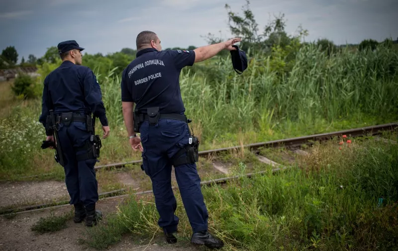 Serbian border police officers check a path next to a railroad close to the border with Hungary, 30 kms east of Subotica, on June 25, 2015. Hungary said it has indefinitely suspended the application of a key EU asylum rule in order "protect Hungarian interests", prompting Brussels to seek immediate clarification. Illegal immigrants cross Serbia on their way to other European countries as it has land access to three members of the 28-nation bloc -- Romania, Hungary and Croatia. The number of immigrants entering Hungary rose from 2,000 in 2012 to 54,000 this year so far. According to official figures, 95 percent of them arrive from Serbia.  AFP PHOTO / ANDREJ ISAKOVIC (Photo by ANDREJ ISAKOVIC / AFP)