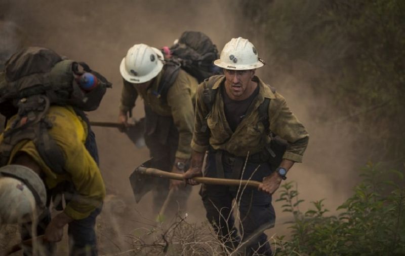 MONTECITO, CA - DECEMBER 16: A Hot Shot crew cuts a line among homes at the Thomas Fire on December 16, 2017 in Montecito, California. The National Weather Service has issued red flag warnings of dangerous fire weather in Southern California for the duration of the weekend. Prior to the weekend, Los Angeles and Ventura counties had 12 consecutive days of red flag fire warnings, the longest sustained period of fire weather warnings on record. The Thomas Fire is currently the fourth largest California fire since records began in 1932, growing to 400 square miles and destroying more than 1,000 structures since it began on December 4.   David McNew/Getty Images/AFP
