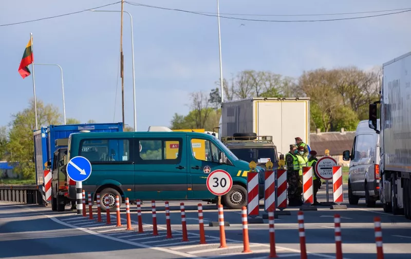 Border police patrol as trucks wait in a queue at the Latvia-Lithuania border crossing in Grenctale, Latvia on May 14, 2020, ahead of border reopening. - After two months of coronavirus-related restrictions, the Baltic States agreed to lift travel restrictions and ensure free movement of their residents by land, sea and air: the so-called 'Baltic Bubble' from May 15, 2020. (Photo by Gints Ivuskans / AFP)
