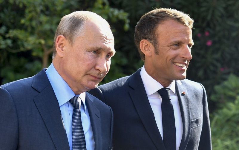 French President Emmanuel Macron (R) welcomes Russia's President Vladimir Putin, at his summer retreat of the Bregancon fortress on the Mediterranean coast, near the village of Bormes-les-Mimosas, southern France, on August 19, 2019, for talks days before the G7 Summit . (Photo by GERARD JULIEN / POOL / AFP)