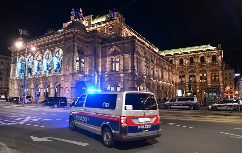 A police car drives in front of the opera house in the center of Vienna on November 2, 2020, following a shooting. - Two people, including one attacker, have been killed in a shooting in central Vienna, police said late November 2, 2020. Vienna police said in a Twitter post there had been "six different shooting locations" with "one deceased person" and "several injured", as well as "one suspect shot and killed by police officers". (Photo by JOE KLAMAR / AFP)