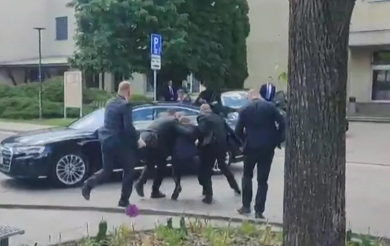 This image taken from video footage obtained by AFPTV shows security personnel carrying Slovakia's Prime Minister Robert Fico (C) towards a vehicle after he was shot in Handlova on May 15, 2024. Slovakia's Prime Minister Robert Fico was battling life-threatening wounds after officials said he was shot multiple times in an assassination attempt condemned by European leaders. (Photo by RTVS / AFP)