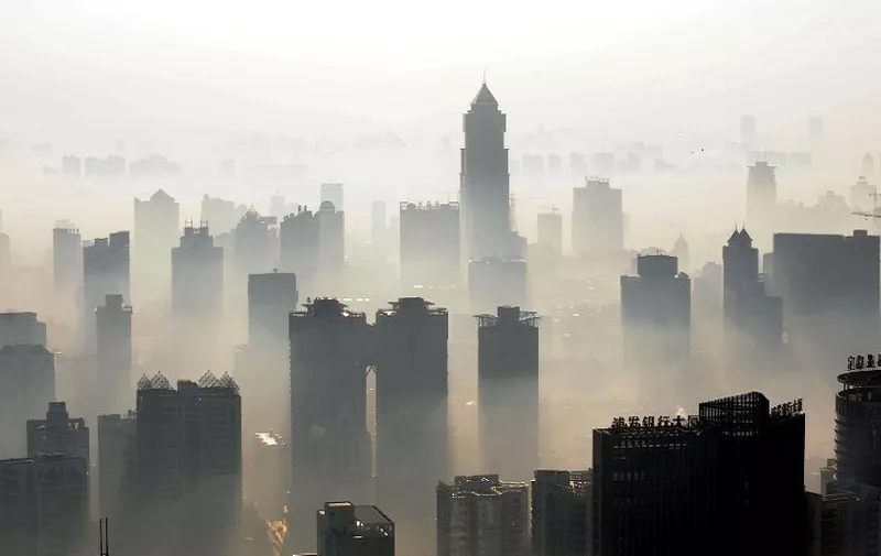 An aerial view of buildings standing out amid haze engulfing Wuhan, central China's Hubei province on December 3, 2009.  China will need to invest up to 30 billion dollars a year to meet its goal of curbing greenhouse gas emissions, the state press said, citing an academic study, as Beijing set its targets before world leaders gather in Copenhagen this month for talks on negotiating a new global warming pact to replace the Kyoto Protocol that expires in 2012. CHINA OUT AFP PHOTO (Photo by STR / AFP)