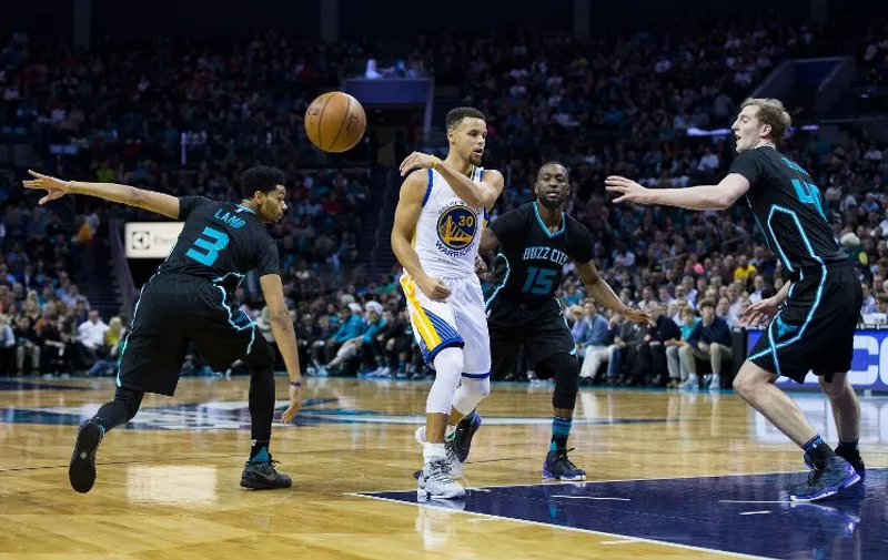 CHARLOTTE, NC - DECEMBER 02: Stephen Curry (30) of the Golden State Warriors makes a no look pass as he is defended by Jeremy Lamb (3), kemba Walker (15) and Cody Zeller (40) of the Charlotte Hornets at Time Warner Cable Arena on December 2, 2015 in Charlotte, North Carolina. The Warriors defeated the Hornets 116-99.   Brian A. Westerholt/Getty Images/AFP