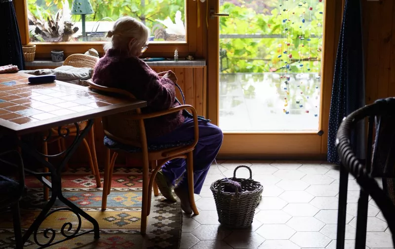 27 August 2021, Thuringia, Zella-Mehlis: An old lady sits in a chair by the window or door to the terrace and knits. Photo: Soeren Stache/dpa-Zentralbild/dpa (Photo by SOEREN STACHE / dpa-Zentralbild / dpa Picture-Alliance via AFP)