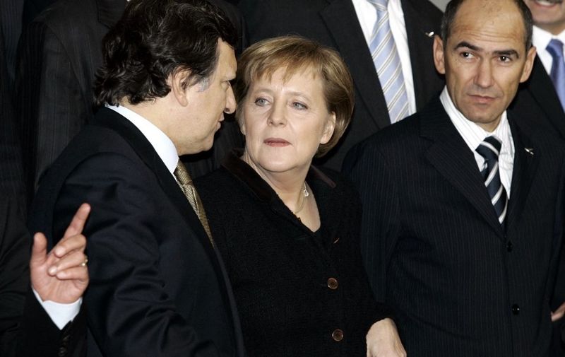 German Chancellor Angela Merkel (C) is flanked by European Commsion President Jose Manuel Barroso (L) and Slovenian Prime Minister Janez Jansa as they take place for a family picture of a European Union summit 15 December 2005, in Brussels. European Union leaders headed Thursday into two days of gruelling negotiations over the bloc's budget at a showdown summit here that has exposed bitter divisions over its future direction. (Photo by GERARD CERLES / AFP)