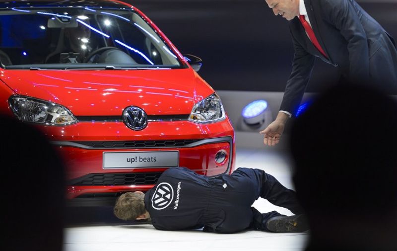 British comedian Simon Brodkin inspects a new model at German carmaker Volkwagen stand next to Volkwagen board member Juergen Stackmann (R) as he disrupts a presentation at the press day of the Geneva Motor Show on March 1, 2016 in Geneva.

Brodkin became famous after he thrown bank notes above former FIFA President Sepp Blatter. / AFP PHOTO / FABRICE COFFRINI