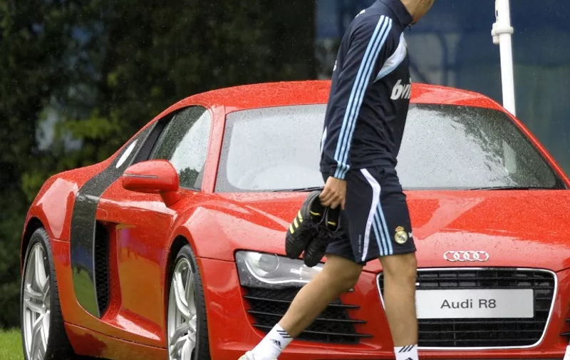 Real Madrid's French Karim Benzema looks at a sport car after their first training session on July 18, 2009 at the Carton House Hotel, in Maynooth, 22 km from Dublin. Real Madrid will stage a nine-day pre-season training camp and includes a friendly match against current Irish champions Shamrock Rovers on July 20.   AFP PHOTO/ MIGUEL RIOPA