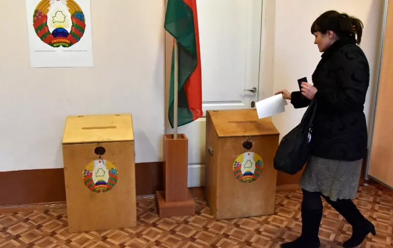 A woman casts her ballot as he votes during presidential elections at a polling station in Minsk on October 11, 2015. Belarussians began voting in an election that is likely to see authoritarian President Alexander Lukashenko claim a fifth term, with the EU possibly lifting sanctions against him if the polls take place without incident.AFP PHOTO / MAXIM MALINOVSKY