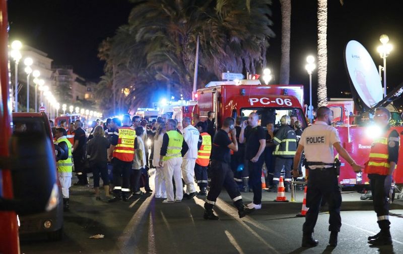 Police officers, firefighters and rescue workers are seen at the site of an attack on July 15, 2016, after a truck drove into a crowd watching a fireworks display in the French Riviera town of Nice.
A truck ploughed into a crowd in the French resort of Nice on July 14, leaving at least 60 dead and scores injured in an "attack" after a Bastille Day fireworks display, prosecutors said on July 15.  / AFP PHOTO / Valery HACHE