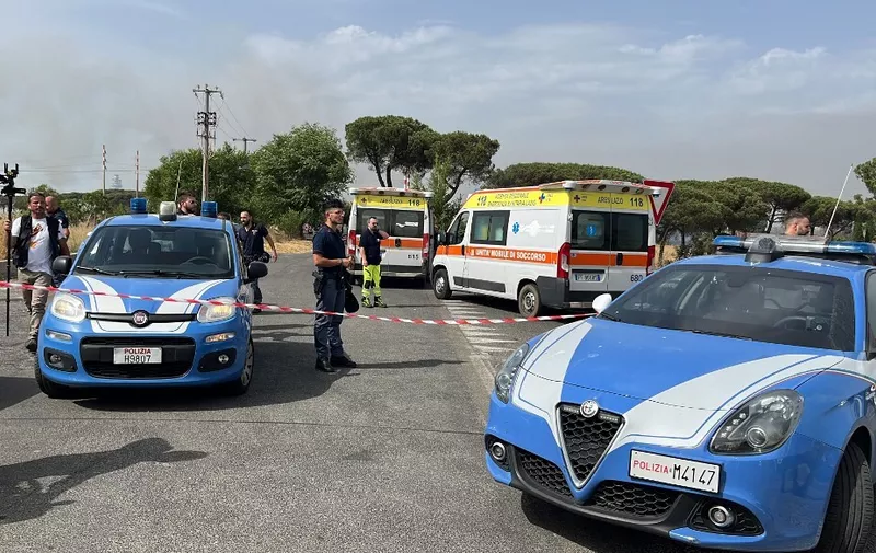 Police controls a cordoned off access after a fire broke out, and the explosion of 50 cylinders of liquified petroleum gas, leading to the evacuation of a summer centre and homes, on June 27, 2022 in the Casalotti area near the Via Aurelia, west of Rome. (Photo by Andreas SOLARO / AFP)
