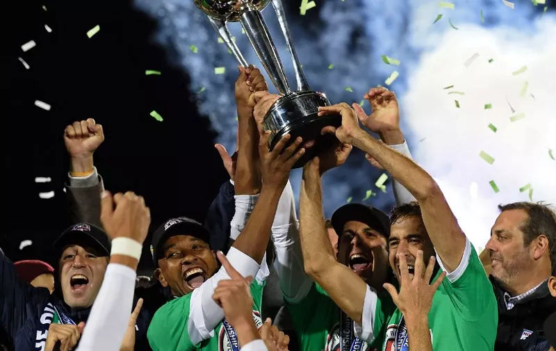 Spanish soccer star Raul (R holding trophy) and teammate Marcos Senna (L holding trophy) celebrates with his teammates after the NASL Championship Final match between the NY Cosmos and the Ottawa Fury November 15, 2015 in Hempstead, NY. Raul has planned to retire after the match. The Cosmos wont the match 3-2. AFP PHOTO/DON EMMERT