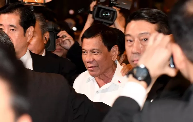 Philippines' President Rodrigo Duterte (C) leaves after meeting with his supporters at a hotel in Tokyo on October 25, 2016.
Duterte is here on a three day visit. / AFP PHOTO / TOSHIFUMI KITAMURA