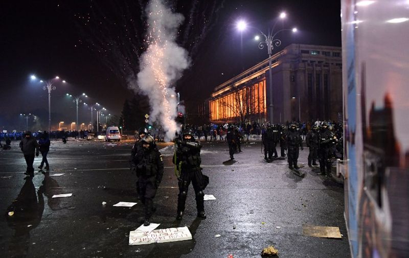 Romanian riot police  fire tear gas to disperse people taking part in a protest against controversial decrees to pardon corrupt politicians and decriminalize other offenses in front of the government headquarters in Bucharest, on February 1, 2017. 
At least 200,000 people hit the streets across Romania on February 1, 2017 for anti-government protests, the largest since communism fell in 1989, media reports said. / AFP PHOTO / DANIEL MIHAILESCU