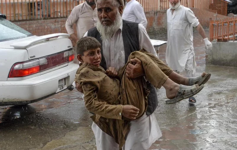 A volunteer carries an injured youth to hospital, following a bomb blast in Haska Mina district of Nangarhar Province on October 18, 2019. - At least 28 worshippers were killed and dozens wounded by a blast inside an Afghan mosque during Friday prayers on October 18, officials said, a day after the United Nations said violence in the country had reached "unacceptable" levels. (Photo by NOORULLAH SHIRZADA / AFP)