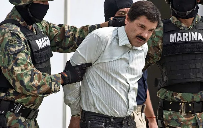 Mexican drug trafficker Joaquin Guzman Loera aka "el Chapo Guzman" (C), is escorted by marines as he is presented to the press on February 22, 2014 in Mexico City. The Sinaloa cartel leader - the most wanted by US and Mexican anti-drug agencies - was arrested early this morning by Mexican marines at a resort in Mazatlan, northern Mexico. AFP PHOTO/RONALDO SCHEMIDT