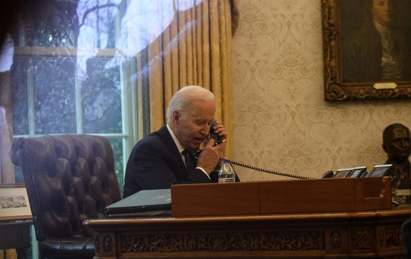 US President Joe Biden speaks on the phone to his Ukrainian counterpart Volodymyr Zelensky in the Oval Office at the White House in Washington, DC, on December 9, 2021. (Photo by Nicholas Kamm / AFP)