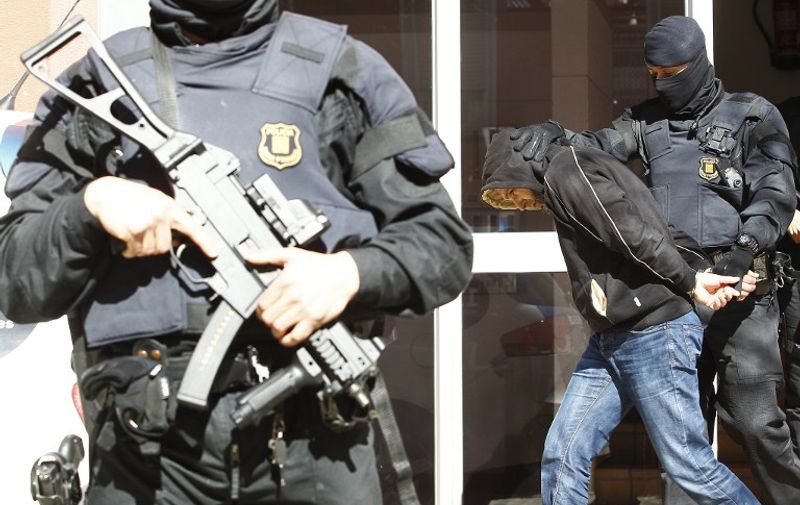 A man suspected of links to Islamic State groups is arrested during an antijihadist police operation in Sabadell on April 8, 2015. Spanish police arrested 10 people in the Catalonia region today suspected of links to the Islamic State group, authorities said, the latest such raids as European nations seek to stop jihadist recruitment. The operation included raids in the Barcelona and Tarragona areas and those arrested are suspected of crimes "linked to jihadist terrorism, particularly to the Islamic State group," police said in a statement.  AFP PHOTO / QUIQUE GARCIA