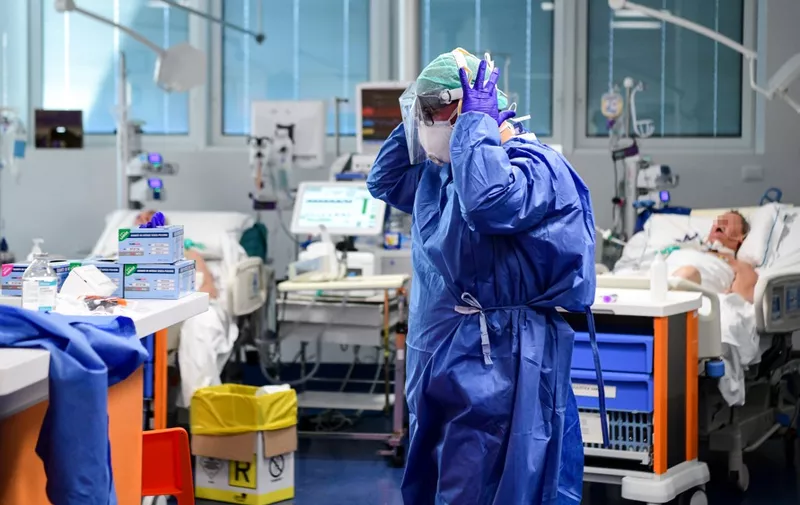 A medical worker wearing a face make and protection gear tends to patients inside the new coronavirus intensive care unit of the Brescia Poliambulanza hospital, Lombardy, on March 17, 2020. (Photo by Piero CRUCIATTI / AFP)