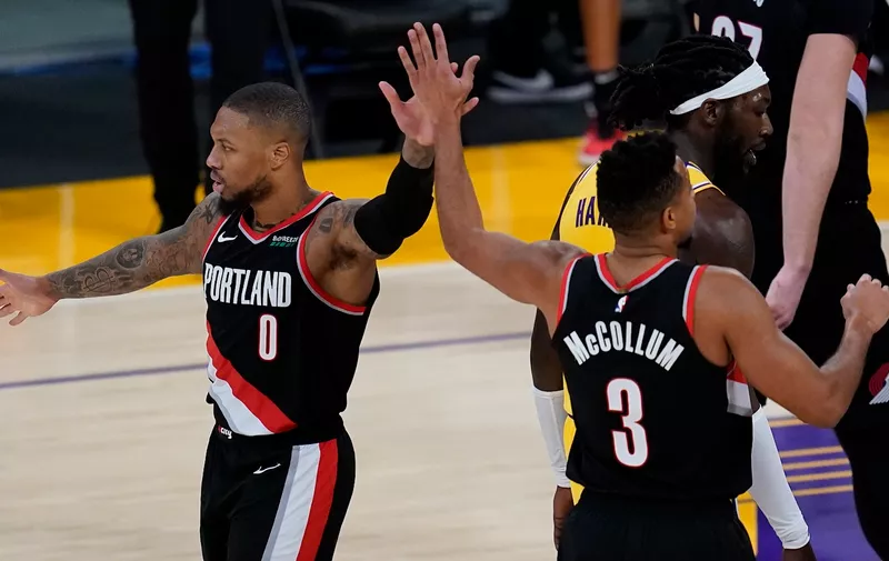 Portland Trail Blazers guard Damian Lillard (0) and guard CJ McCollum (3) celebrate after a score during the fourth quarter of the team's NBA basketball game against the Los Angeles Lakers on Monday, Dec. 28, 2020, in Los Angeles. (AP Photo/Ashley Landis)