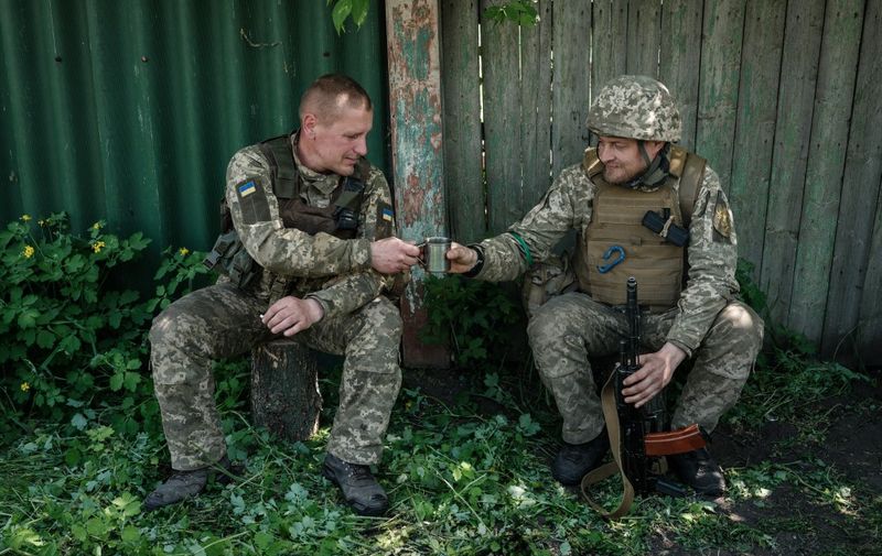 Ukrainian soldiers drink a cup of coffee in Seversk, eastern Ukraine, on May 8, 2022, as they wait to move to Pereizne, amid the Russian invasion of Ukraine. (Photo by Yasuyoshi CHIBA / AFP)