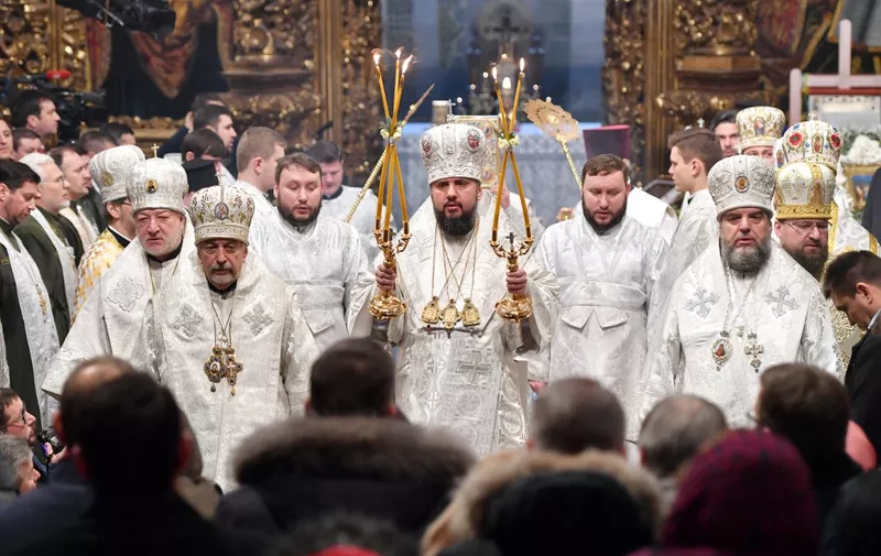 Believers attend as the head of the independent Ukrainian Orthodox Church Metropolitan Epiphanius (or Yepifaniy) (C) serves during the Orthodox Christmas service in Saint Sophia cathedral in Kiev on January 7, 2019. Ukraine's newly created independent church held its first service in Kiev on January 7, a day after the Istanbul-based Orthodox patriarch presented a formal decree that completes its formation. (Photo by Sergei SUPINSKY / AFP)
