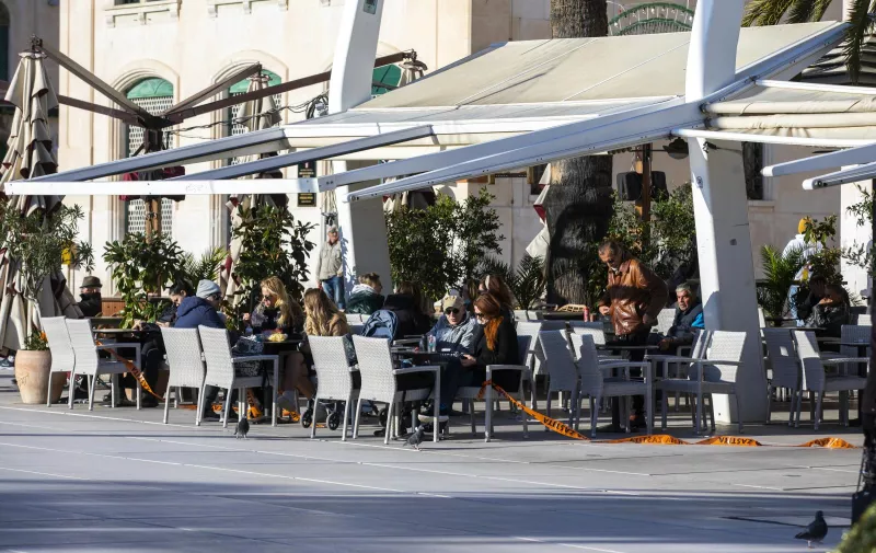 30.11.2020., Split - Bura je potrgala trake koje su postavili pripadnici Civilne zastite na stekate kafica, a to su Splicani brzo iskoristili za sjesti sa svojim 'kavama za van'.
Photo: Miroslav Lelas/PIXSELL