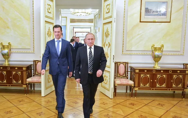 Russian President Vladimir Putin (R) greets his Syrian counterpart Bashar al-Assad upon his arrival for a meeting at the Kremlin in Moscow on October 20, 2015. Assad, on his first foreign visit since Syria's war broke out, told his main backer and counterpart Putin in Moscow that Russia's campaign in Syria has helped contain "terrorism". AFP PHOTO / RIA NOVOSTI / KREMLIN POOL / ALEXEY DRUZHININ