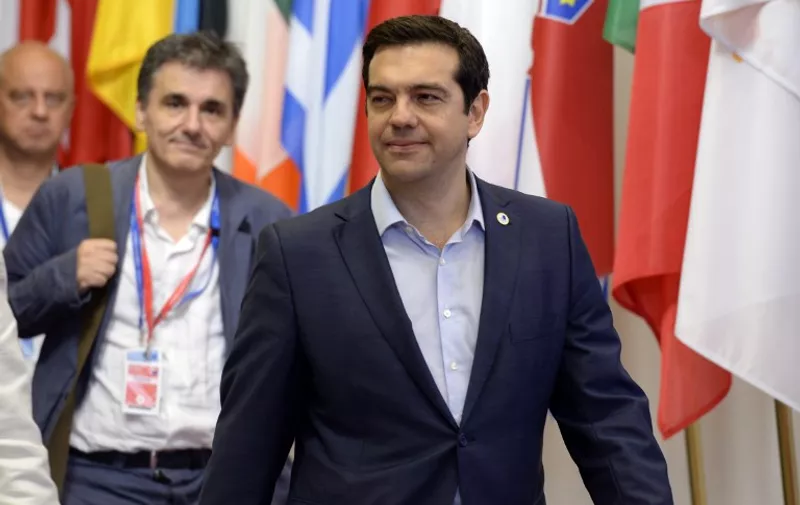 Greek Prime Minister Alexis Tsipras (R) and Finance Minister Euclide Tsakalotos leave at the end of an Eurozone Summit over the Greek debt crisis in Brussels on July 13, 2015. Juncker said there was no longer any risk of Greece crashing out of the euro after Athens agreed a bailout deal with eurozone partners.  AFP PHOTO / THIERRY CHARLIER
