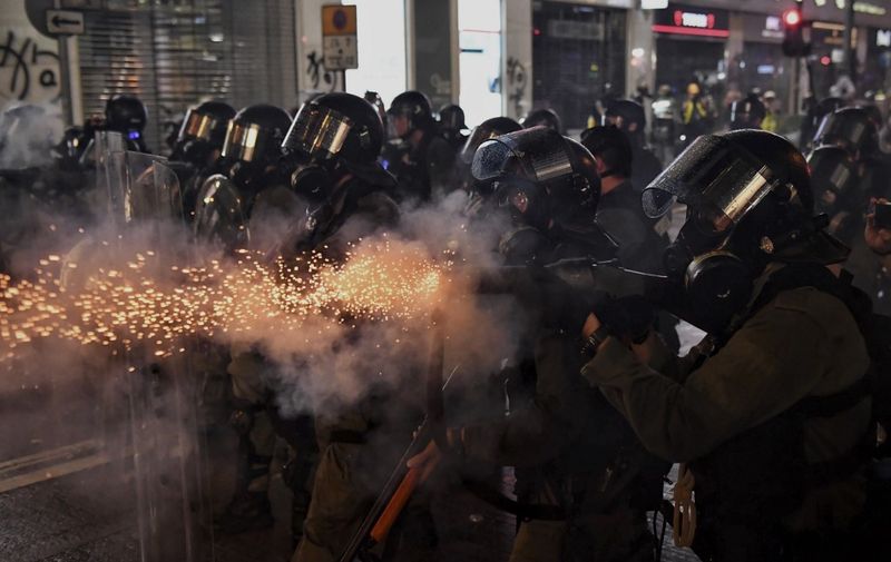 Police fire tear gas at protesters on Hennessy Road, in Hong Kong on August 31, 2019, in the latest opposition to a planned extradition law that has since morphed into a wider call for democratic rights in the semi-autonomous city. - Chaos engulfed Hong Kong's financial heart on August 31 as police fired tear gas and water cannon at petrol bomb-throwing protesters, who defied a ban on rallying -- and mounting threats from China -- to take to the streets for a 13th straight weekend. (Photo by Lillian SUWANRUMPHA / AFP)